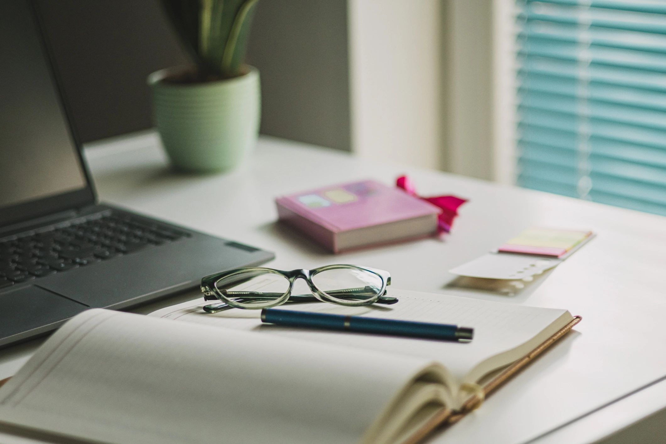 Editorial workspace with laptop, coffee, and glasses